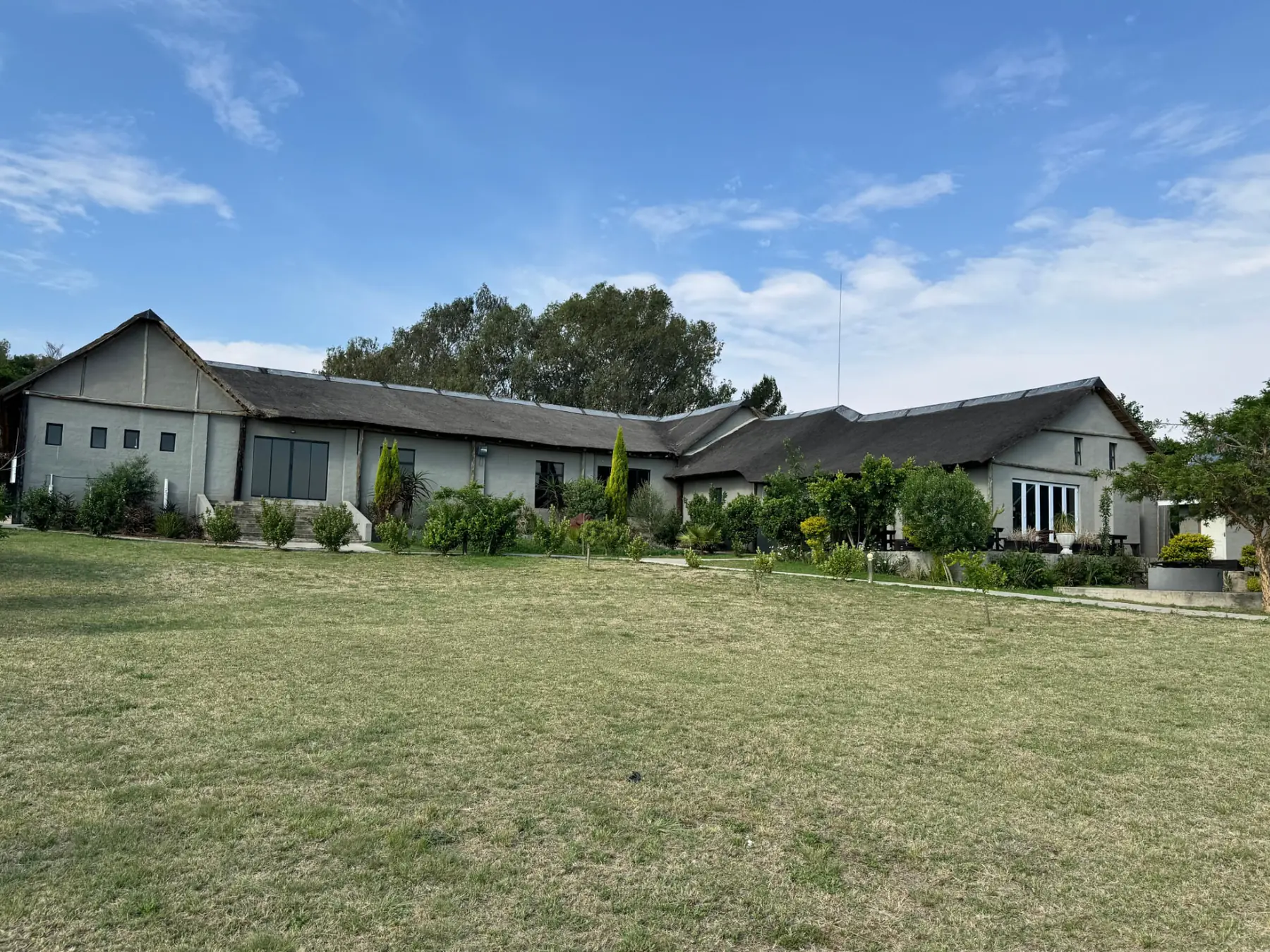 Thatched estate buildings across the open lawn