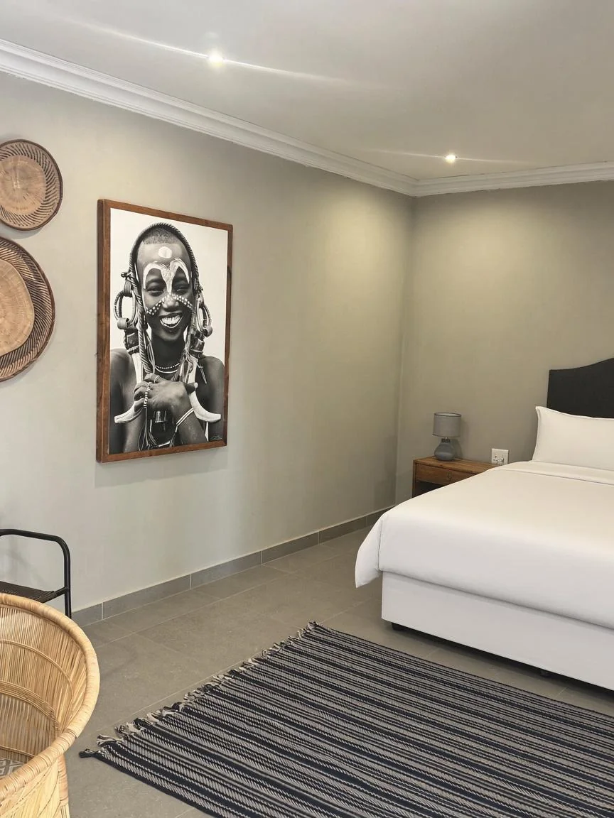 Portrait artwork and woven textures inside a guest room